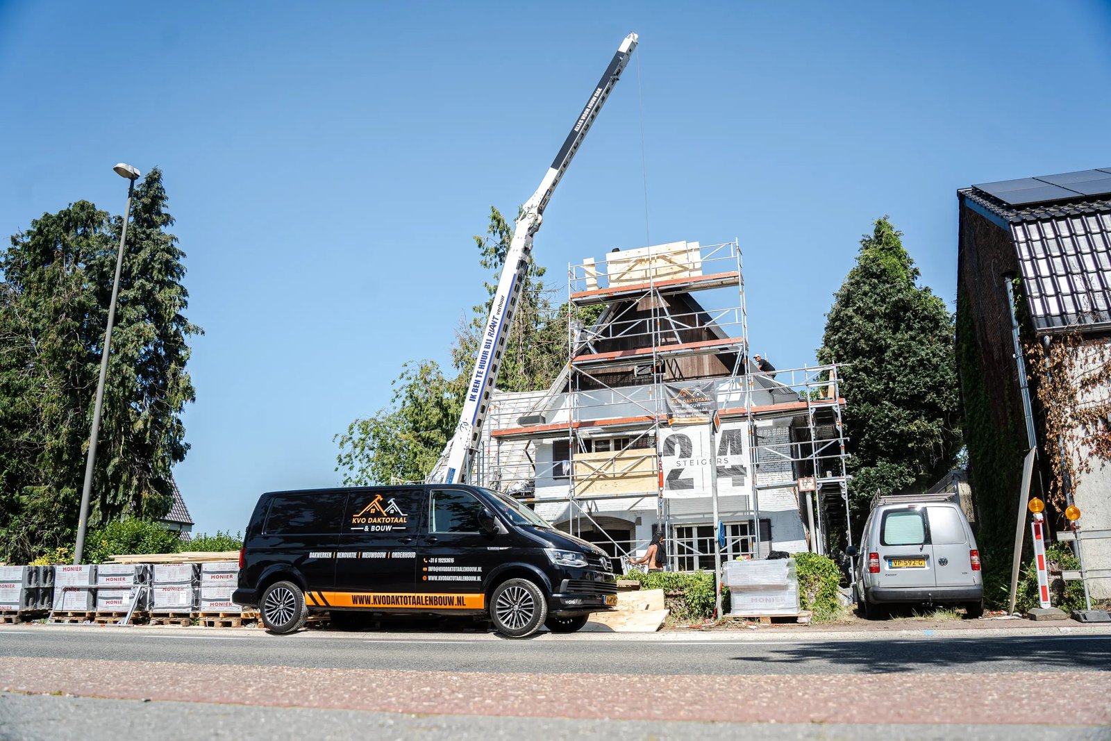 Kraan en bus bij de woning